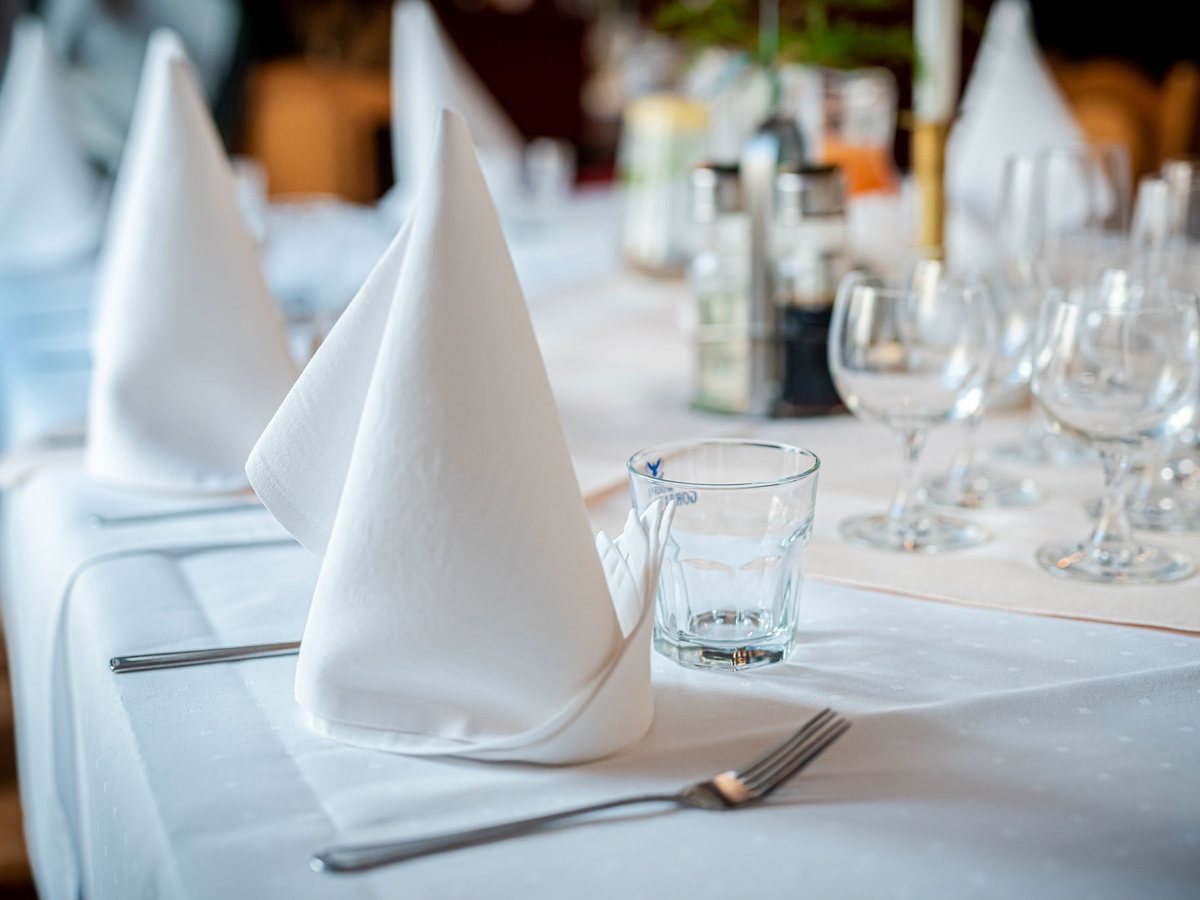 Biały obrus i serwetki w sali restauracyjnej
